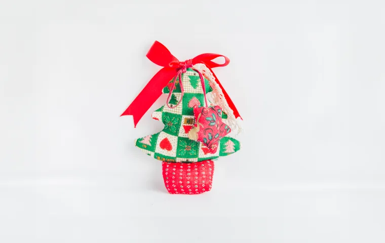 Fabric Christmas tree ornament tied with a red ribbon bow
