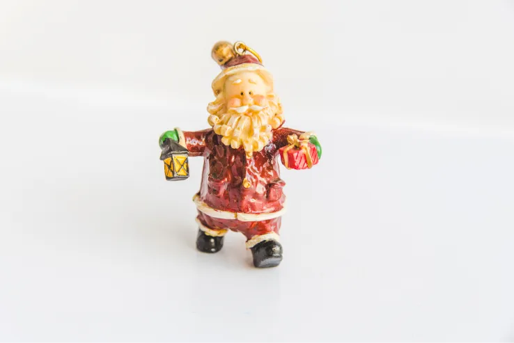 Santa Claus figurine ornament holding a lantern and gifts