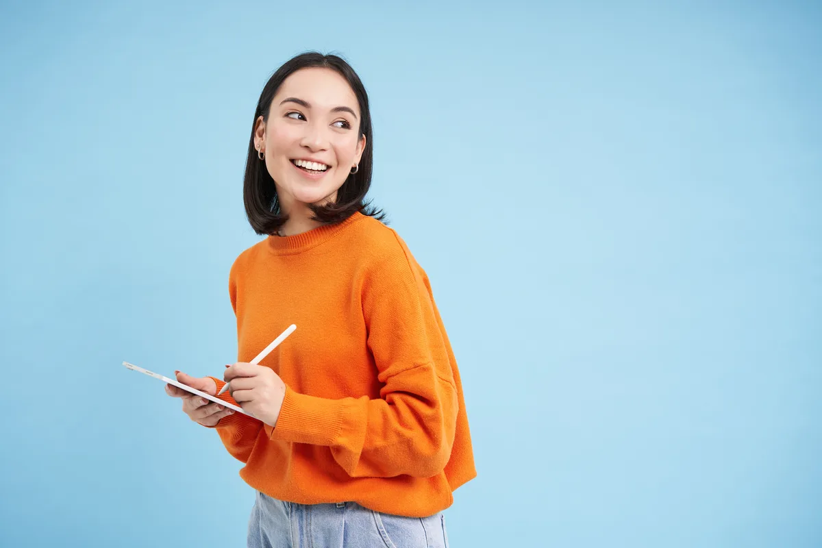 Student smiling while taking notes during a lesson