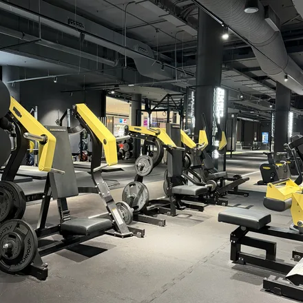 A gym floor lined with yellow resistance machines