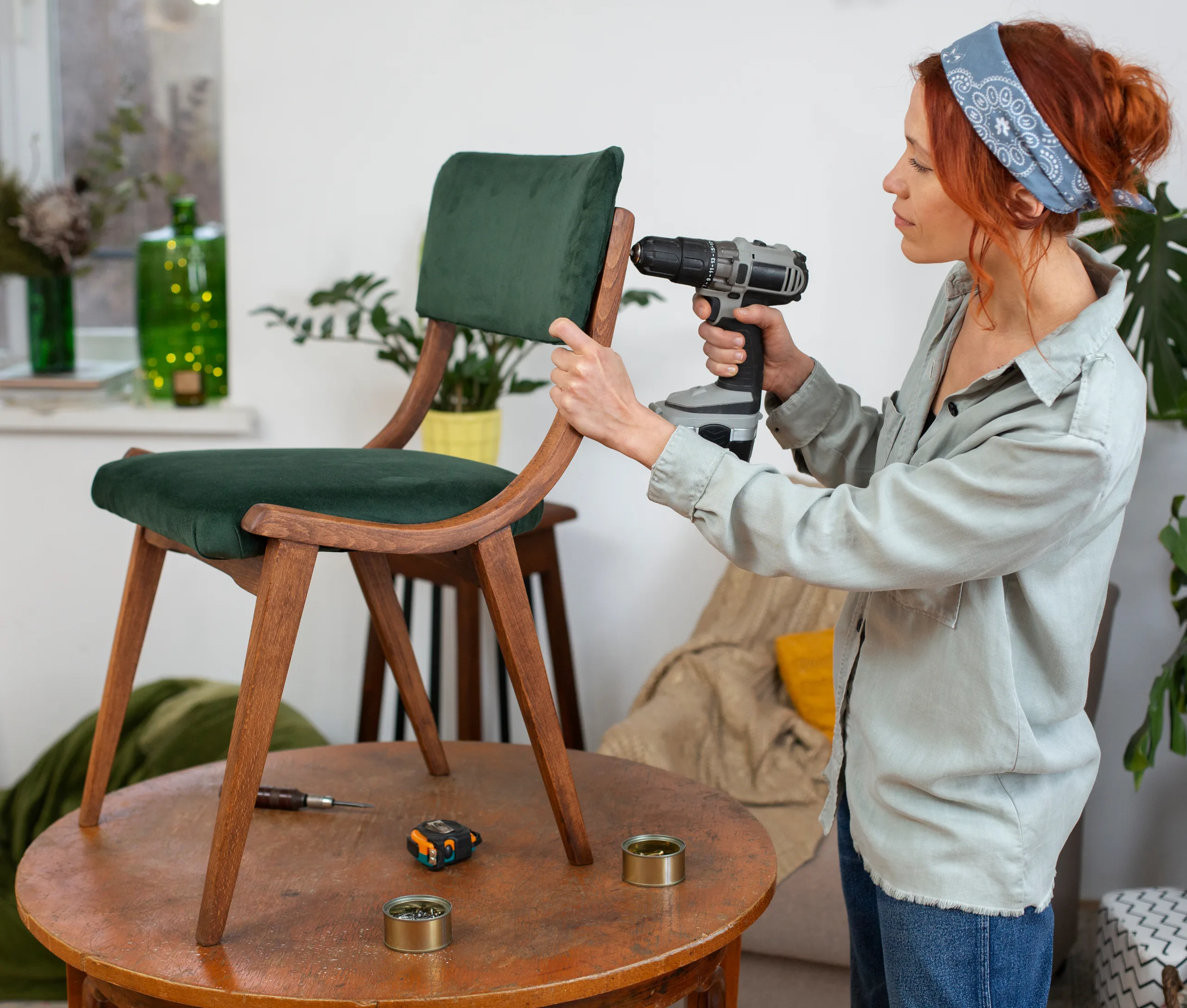 Upholsterer fitting a green velvet seat to a walnut chair frame