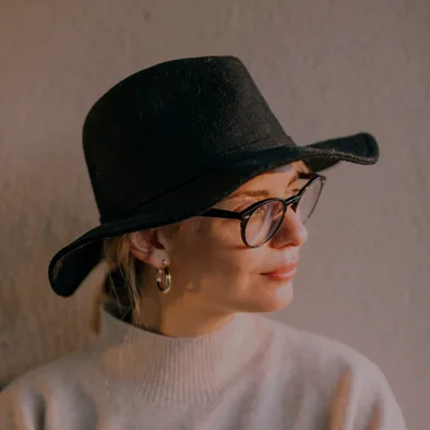 Woman in a black bucket hat and round glasses