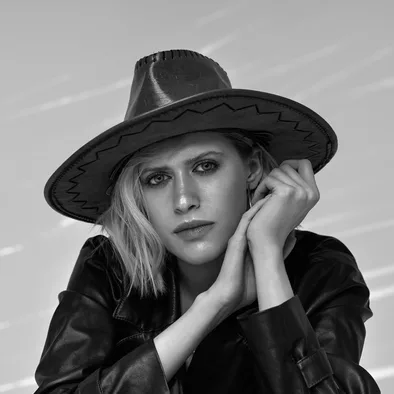 Woman in a black wide brim hat and a leather jacket