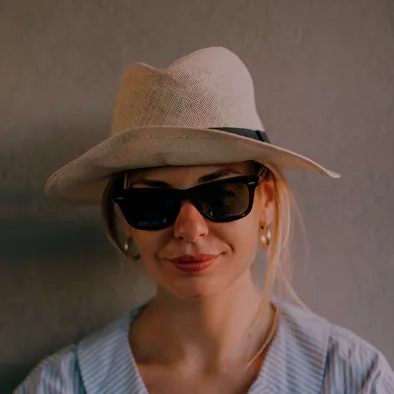 Woman in a straw fedora hat and sunglasses