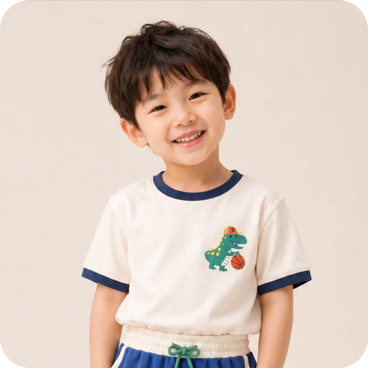 Young boy in a white ringer tee with a dinosaur print