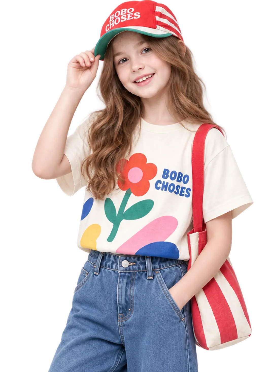 Girl in a red cap and printed tee carrying a striped tote