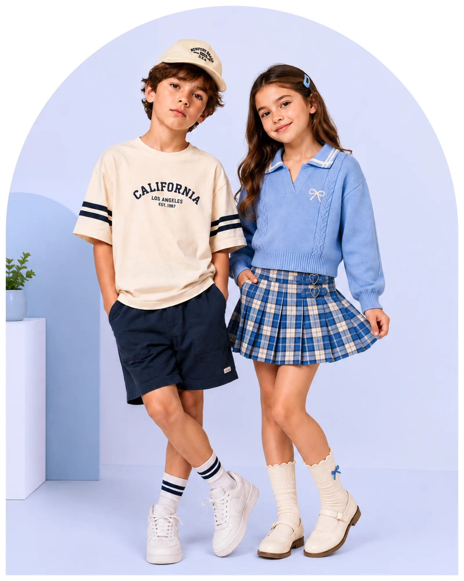 A boy and a girl in coordinated blue and cream outfits standing side by side