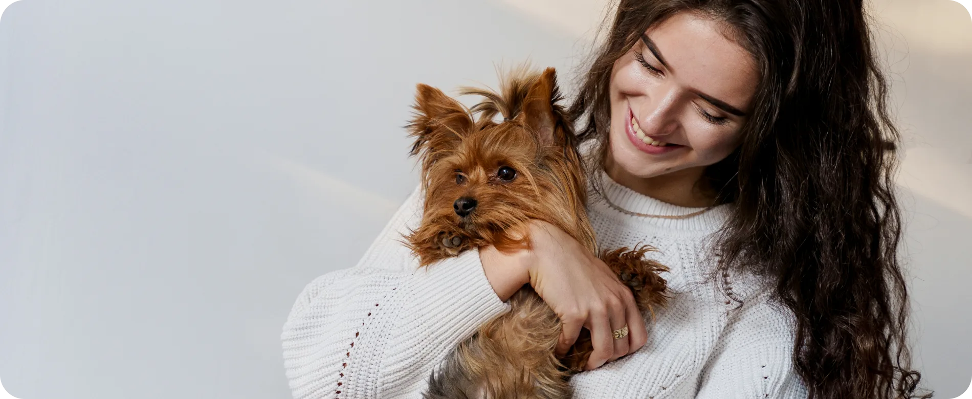Smiling pet owner holding a small dog