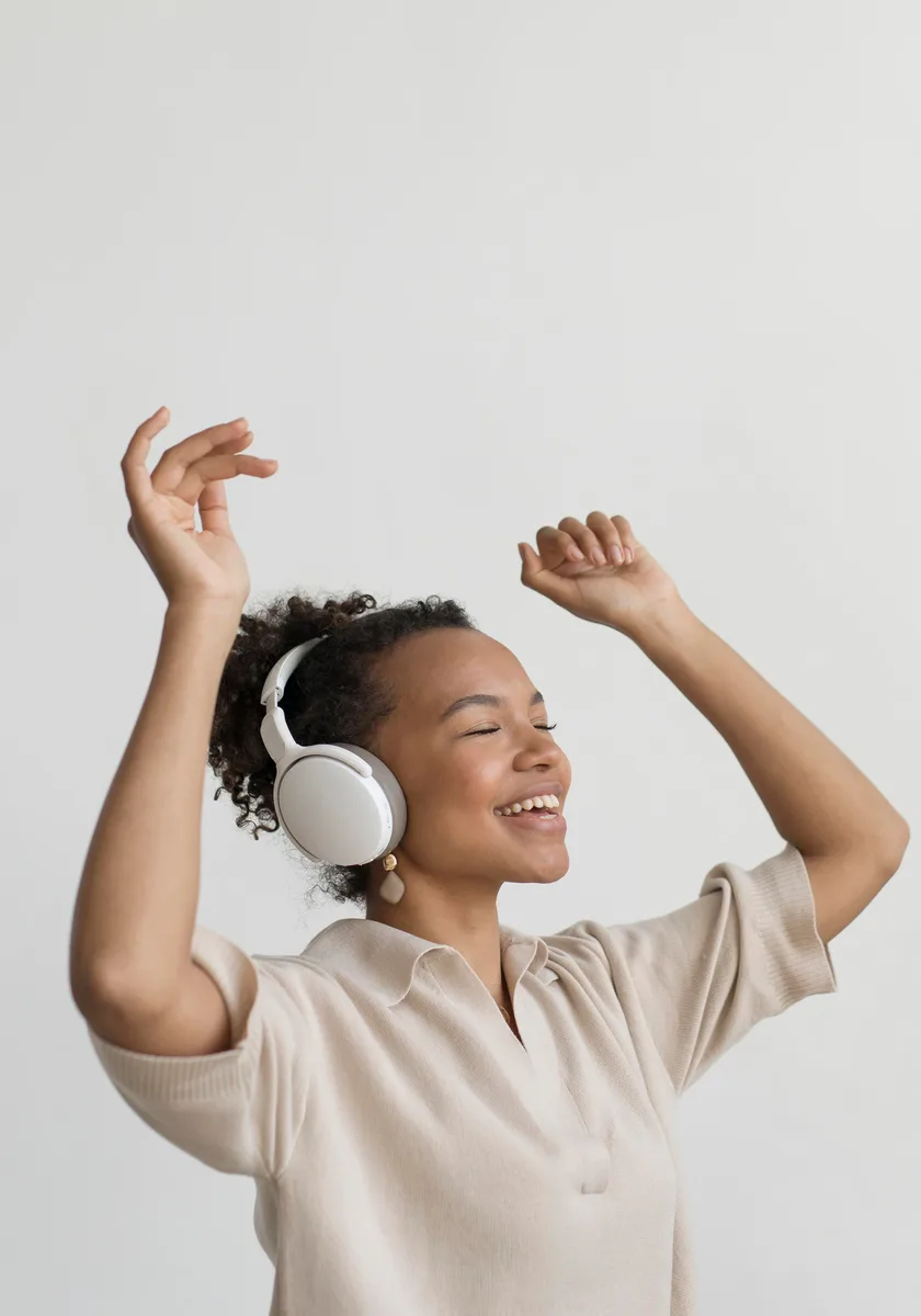 Customer dancing while wearing white over-ear headphones